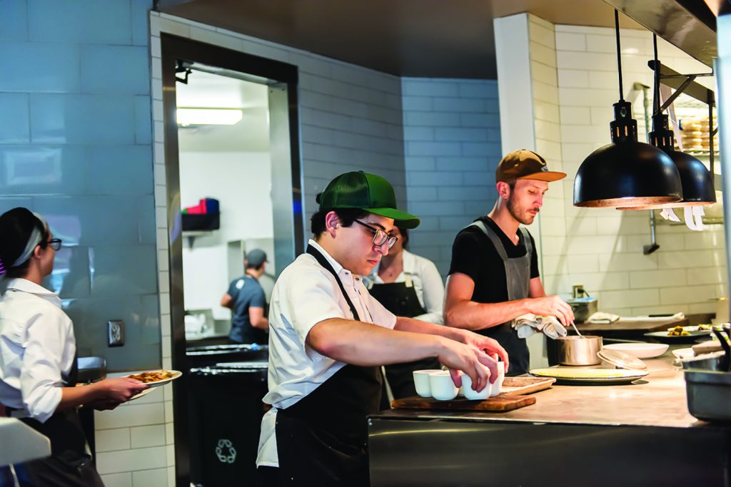 A chef plates an entree at Oak during First Bite 2023